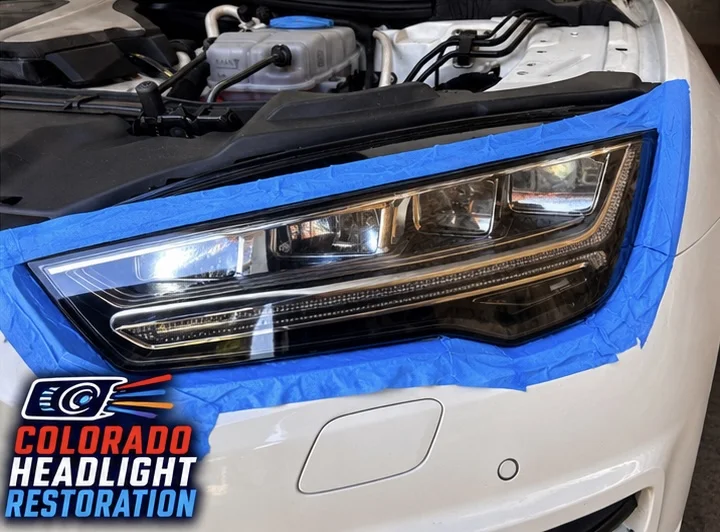 White SUV headlight with blue protective masking tape