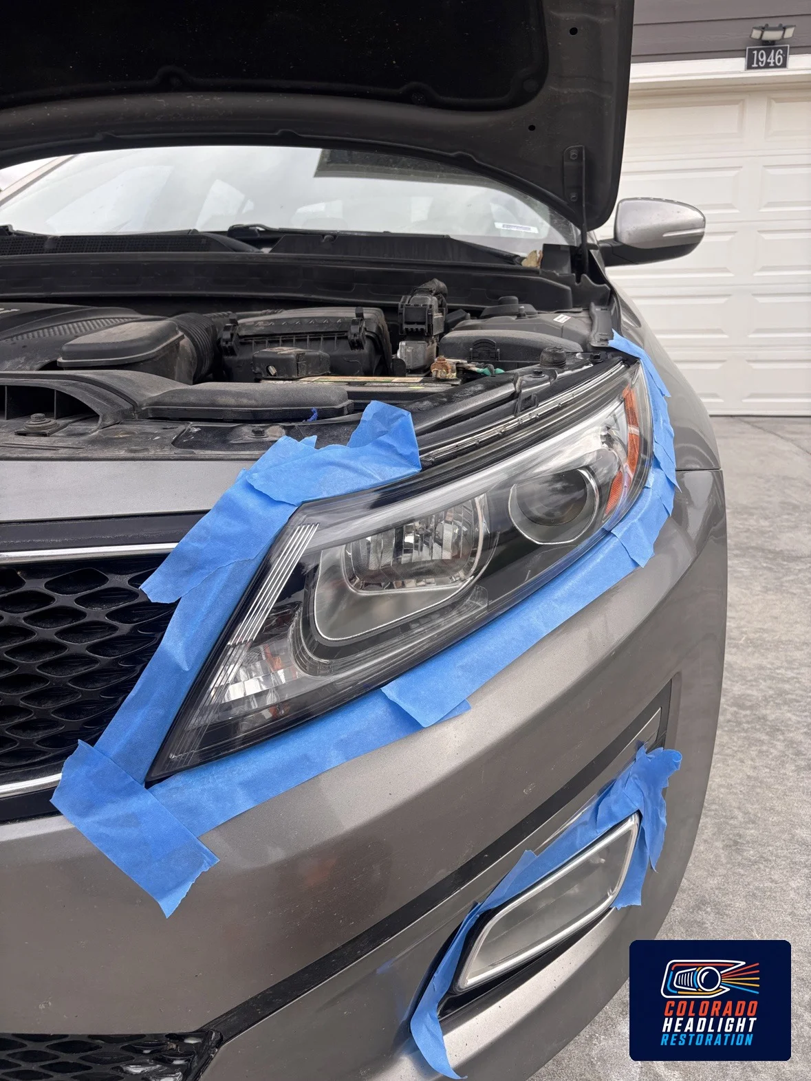 Silver car headlight lens with blue protective masking tape
