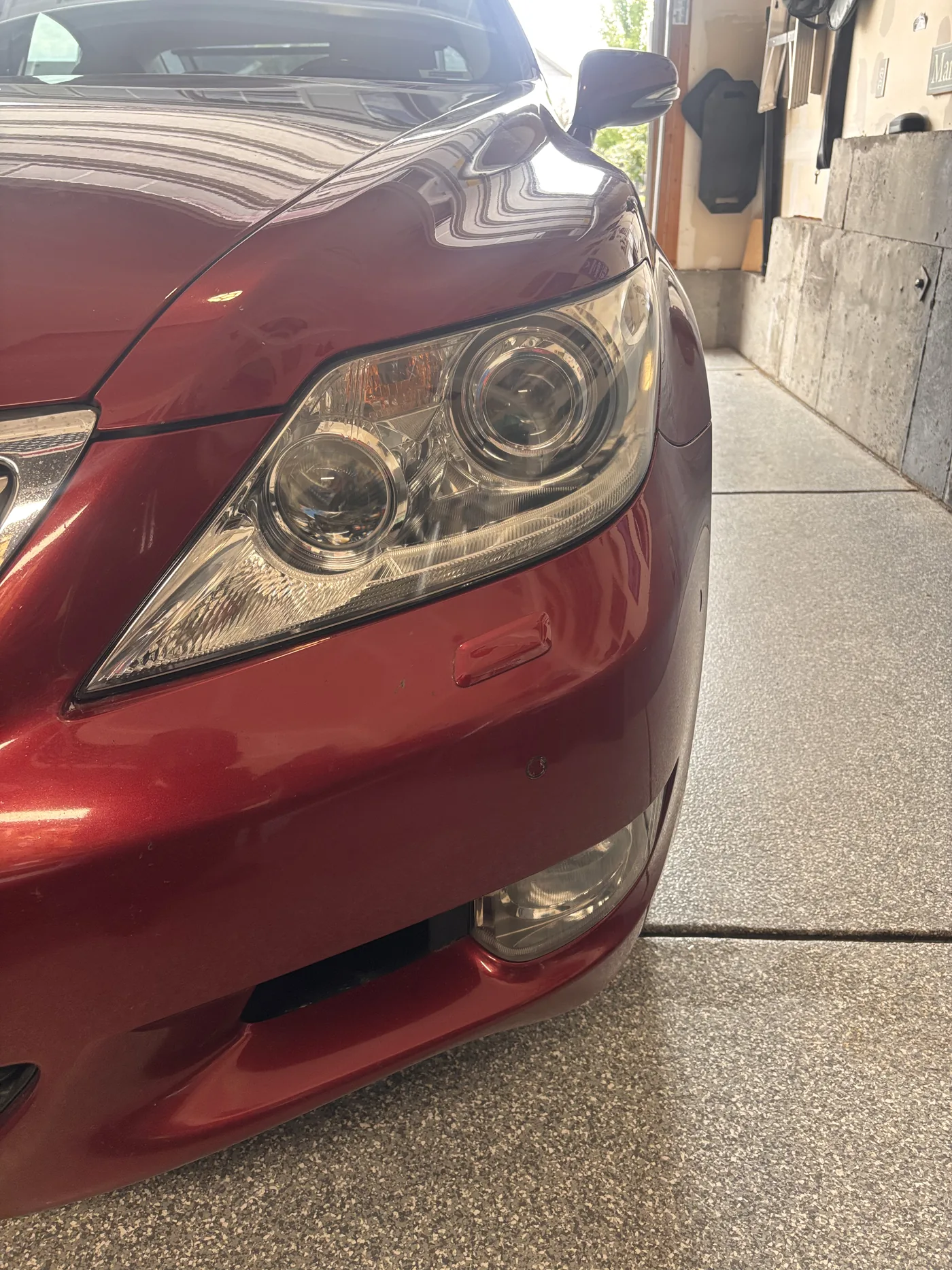 Red sedan headlight lens close-up before restoration
